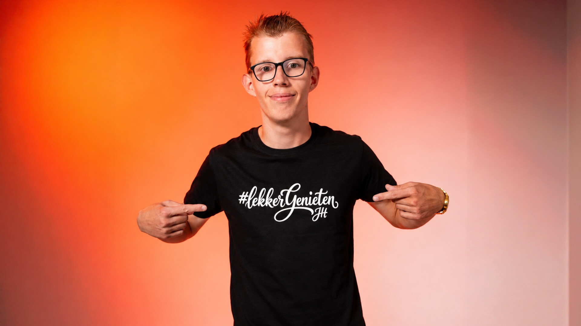 Jesse Hoeré in een zwart shirt tegen een oranje achtergrond